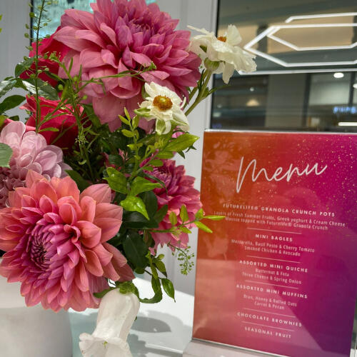 9 Yard Marketing event décor with floral arrangements and branded signage.